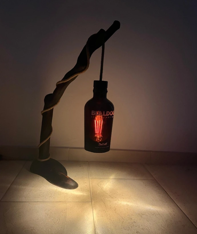 Lampe décorative artisanale créée à partir d’une branche naturelle et une bouteille travaillée